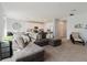 Spacious living room featuring a comfortable gray sectional sofa and open access to the modern kitchen at 3047 Adams Cross Dr, Zephyrhills, FL 33540