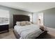 Comfortable main bedroom featuring a tufted headboard bed and lots of natural light from the windows at 3047 Adams Cross Dr, Zephyrhills, FL 33540
