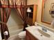 The bathroom showcases a single sink vanity with a combination tub and shower with storage shelves at 3111 Great Oak St, Wesley Chapel, FL 33543