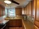 Well-lit kitchen features wood cabinetry, countertop, backsplash, stainless steel sink and appliances at 3111 Great Oak St, Wesley Chapel, FL 33543