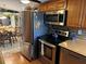 A kitchen with stainless steel appliances, wood cabinets and a view of the dining area at 3111 Great Oak St, Wesley Chapel, FL 33543