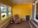 A bright sunroom with large windows is furnished with a floral recliner and a small side table at 3111 Great Oak St, Wesley Chapel, FL 33543