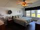 Cozy main bedroom featuring a plush bed, decorative wreath, dark wood floors and great natural light at 3111 Great Oak St, Wesley Chapel, FL 33543