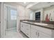 Bright bathroom featuring a double sink vanity with granite countertop and neutral colored walls at 31440 Barrel Wave Way, Wesley Chapel, FL 33545