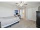 Bedroom with a ceiling fan and white trim, plus view into adjacent full bath at 31440 Barrel Wave Way, Wesley Chapel, FL 33545