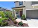 Inviting home entrance with landscaped garden, covered porch, and elegant details at 31440 Barrel Wave Way, Wesley Chapel, FL 33545