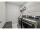 Laundry room with modern washer and dryer, a gray quilted bench, and a wire rack at 31440 Barrel Wave Way, Wesley Chapel, FL 33545