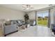 Comfortable living room with tile flooring, neutral furniture, and sliding door access to backyard at 31440 Barrel Wave Way, Wesley Chapel, FL 33545