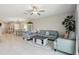 Open-concept living area featuring tile floors, grey furniture, and lots of natural light from windows at 31440 Barrel Wave Way, Wesley Chapel, FL 33545