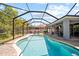 Screened backyard pool with in-pool seating area, lounge chairs and a covered patio for outdoor entertaining at 3159 Marisa Pl, Holiday, FL 34691