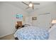 Comfortable bedroom featuring a cozy bed, ceiling fan, and wall decor at 3159 Marisa Pl, Holiday, FL 34691