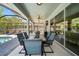 Covered patio offers outdoor dining space with table, chairs, ceiling fans, and pool view through sliding glass doors at 3159 Marisa Pl, Holiday, FL 34691