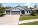 Charming single-story home with a three-car garage, manicured lawn, and inviting curb appeal at 3159 Marisa Pl, Holiday, FL 34691