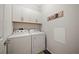 Bright laundry room features a washer, dryer, white cabinets and decorative 'Laundry' wall art for an organized space at 3159 Marisa Pl, Holiday, FL 34691