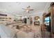 Open living room with a modern sofa, ceiling fan, and access to a kitchen with white cabinets at 3159 Marisa Pl, Holiday, FL 34691