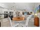 Open concept living and dining area with white sofa, ceiling fan and kitchen with black island at 3159 Marisa Pl, Holiday, FL 34691