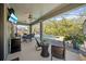 Covered patio with ceiling fan, television, outdoor seating and views of the screened pool and lush landscaping at 3159 Marisa Pl, Holiday, FL 34691