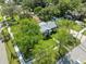 Aerial view of a home with mature trees, lush green lawn, and a white picket fence, presenting a charming exterior at 317 N Washington Ave, Clearwater, FL 33755