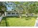 Spacious backyard with lush green grass and mature trees, enclosed by a charming white picket fence at 317 N Washington Ave, Clearwater, FL 33755