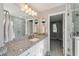 Bright bathroom featuring a granite vanity and a frameless glass shower, providing a modern look at 317 N Washington Ave, Clearwater, FL 33755