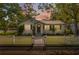 Charming single-story home with a white picket fence and a well-manicured lawn at dusk at 317 N Washington Ave, Clearwater, FL 33755