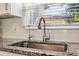 Close-up of kitchen sink with granite countertop, modern faucet, and natural light from the window at 317 N Washington Ave, Clearwater, FL 33755