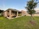 Well-maintained backyard with a covered patio, green lawn, and partial fence, ideal for outdoor activities at 33034 Sand Creek Dr, Wesley Chapel, FL 33543