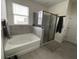 Well-lit bathroom with a soaking tub, tiled walls, and a glass-enclosed shower at 33034 Sand Creek Dr, Wesley Chapel, FL 33543