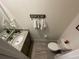 Cozy half bathroom featuring a granite countertop vanity, toilet, and decorative accents at 33034 Sand Creek Dr, Wesley Chapel, FL 33543