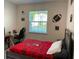 Bright bedroom featuring a Buccaneers-themed comforter, a comfortable work space, and natural light from the window at 33034 Sand Creek Dr, Wesley Chapel, FL 33543