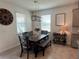 Dining room featuring a wooden table, upholstered bench seating, and elegant light fixture at 33034 Sand Creek Dr, Wesley Chapel, FL 33543