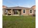 Exterior view of the home with a covered patio, a well-kept lawn, and an air conditioning unit at 33034 Sand Creek Dr, Wesley Chapel, FL 33543