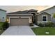 Beautiful single-Gathering home featuring a two-car garage, manicured lawn, and a welcoming entrance at 33034 Sand Creek Dr, Wesley Chapel, FL 33543