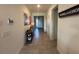 Hallway with neutral tile flooring and decorative shelving leads to the home's front door at 33034 Sand Creek Dr, Wesley Chapel, FL 33543