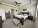 Main bedroom boasts tray ceiling, ceiling fan, and rustic wooden furniture set at 33034 Sand Creek Dr, Wesley Chapel, FL 33543