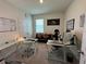 Well-lit home office featuring dual desks, neutral colors, and comfortable seating area at 33034 Sand Creek Dr, Wesley Chapel, FL 33543
