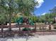 Community playground featuring green slides, wood features, a canopy, bench seating, and wood chip ground cover at 33034 Sand Creek Dr, Wesley Chapel, FL 33543