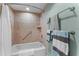 Bathroom showcasing tiled shower/tub with safety bar and light green walls at 36750 Us 19 N # 24-104, Palm Harbor, FL 34684