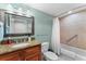 Bathroom featuring a granite countertop, tile flooring, and a shower-tub combo with a grab bar at 36750 Us 19 N # 24-104, Palm Harbor, FL 34684