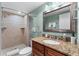 Bathroom features a stone tiled shower, a granite countertop, and a large mirror above a wooden cabinet at 36750 Us 19 N # 24-104, Palm Harbor, FL 34684