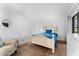Bright bedroom features a wood floor, a queen bed with light wood frame, and a round mirror on the wall at 36750 Us 19 N # 24-104, Palm Harbor, FL 34684