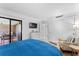 Bedroom boasts sliding glass door access to the balcony, along with a mounted TV and chair with table at 36750 Us 19 N # 24-104, Palm Harbor, FL 34684
