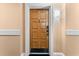 A wood front door with classic trim, number 3384, located in a neutral hallway with a decorative light fixture at 36750 Us 19 N # 24-104, Palm Harbor, FL 34684