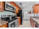 Well-equipped kitchen with granite countertops, stainless steel appliances, and wood cabinetry at 36750 Us 19 N # 24-104, Palm Harbor, FL 34684