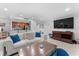 Open concept living area featuring tile floors, a large TV, and a view of the kitchen with stainless appliances at 36750 Us 19 N # 24-104, Palm Harbor, FL 34684