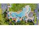 Overhead view of a resort-style pool area surrounded by landscaping, umbrellas, and lounge chairs at 36750 Us 19 N # 24-104, Palm Harbor, FL 34684