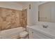 Well-lit bathroom with a white sink and cabinet, tiled tub and shower, and neutral colored tile floor at 3751 Pompano Se Dr # 3751, St Petersburg, FL 33705