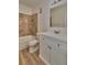 Well-lit bathroom with a white sink and cabinet, tiled tub and shower, and neutral colored tile floor at 3751 Pompano Se Dr # 3751, St Petersburg, FL 33705