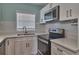 Close-up of the kitchen's stainless steel oven and microwave with white countertops and subway tile backsplash at 3751 Pompano Se Dr # 3751, St Petersburg, FL 33705
