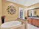 Bathroom features a soaking tub, granite counter tops, vanity and modern mirror at 3913 Little Egret Ct, Lutz, FL 33558